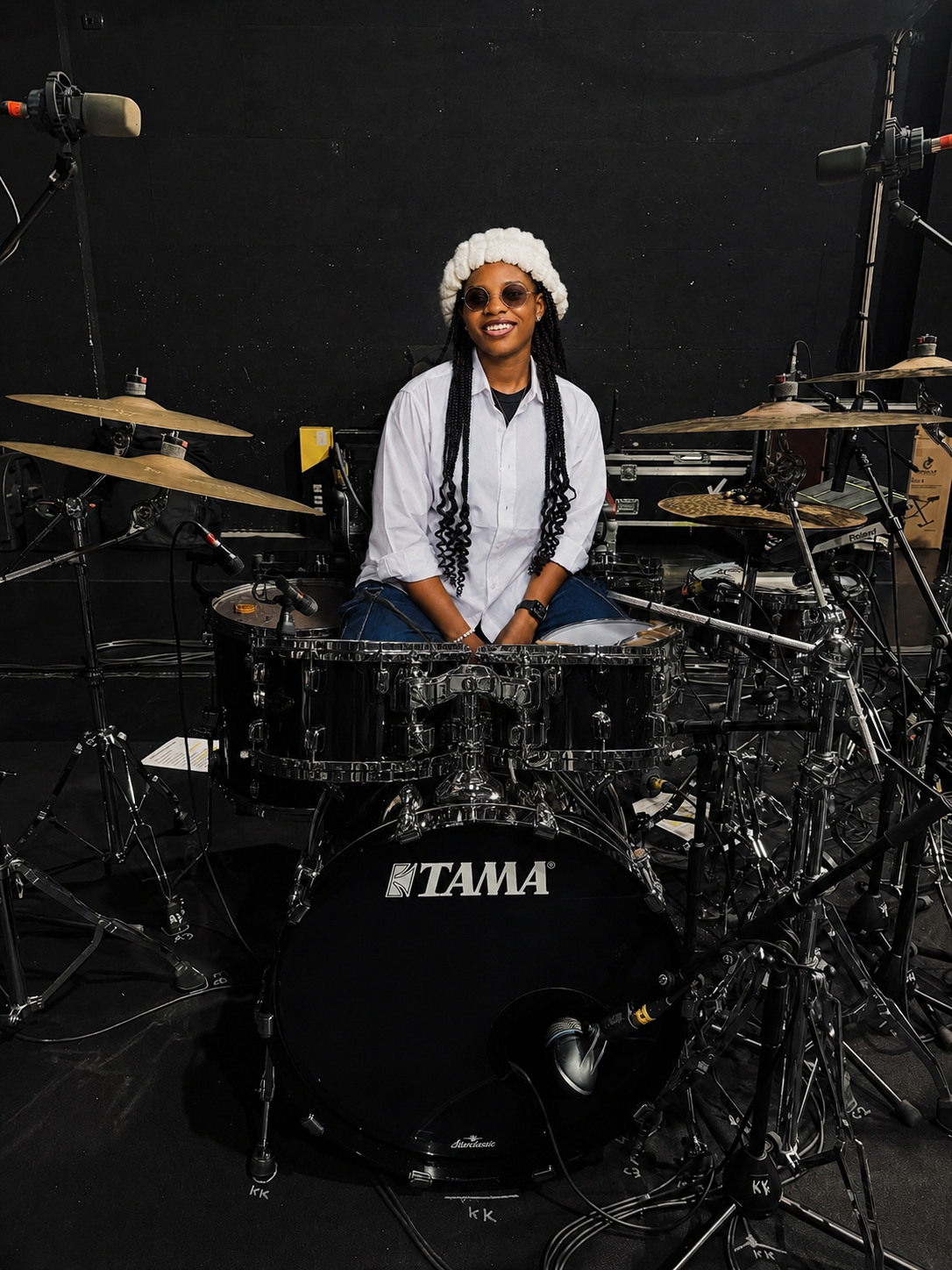 StarBlessing seated behind her full drum kit in a darkened rehearsal room