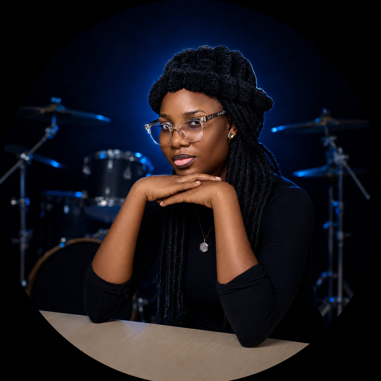 Editorial portrait of StarBlessing beside her kit under blue stage light